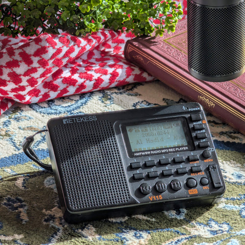 TDBR Qur'ān Radio playing Taraweeh recitation of Surah Al-Hadid on a prayer rug beside a Qur'ān and keffiyeh, Taraweeh Al Haramain Pack