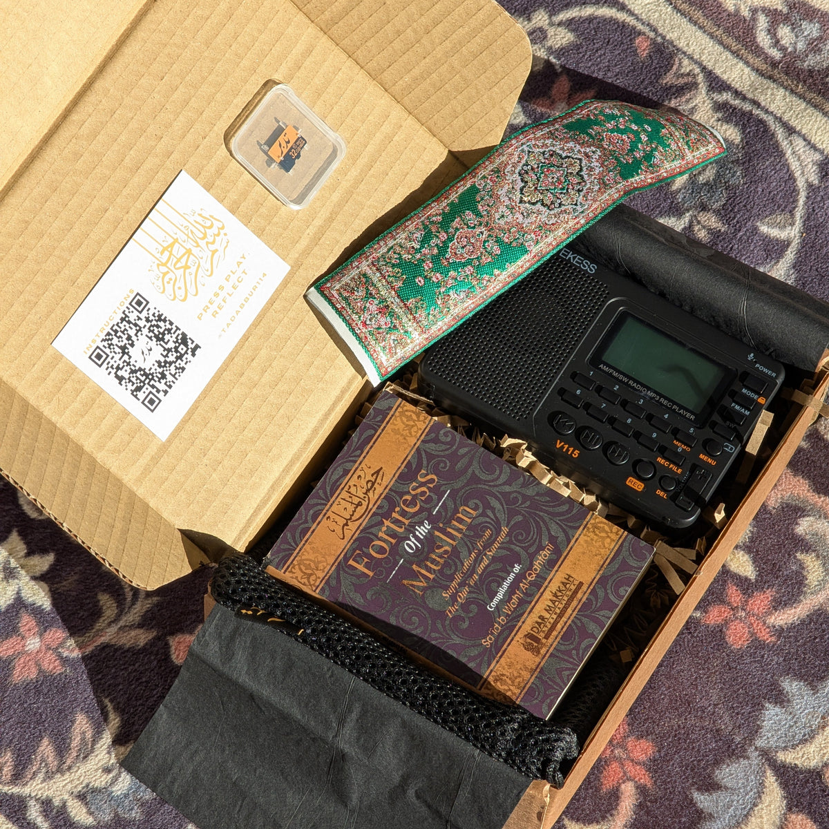 An open TDBR box with Radio+, library card, pouch, book and Bookmark